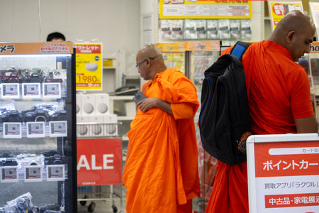 Tokyo, Japan, November 6, 2023: Buddhist monks with smartphones in electronics storeのeditorial素材