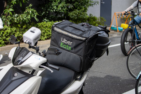 Tokyo, Japan, November 6, 2023: Uber Eats delivery scooter parked on the streetのeditorial素材