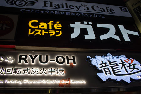 Tokyo, Japan, November 6, 2023: Illuminated Signboards of a Cafe and Mutton Skewer Restaurant at Nightのeditorial素材