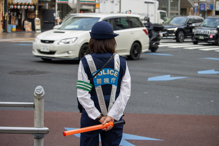 Tokyo, Japan, November 6, 2024: Policewoman Directing Trafficのeditorial素材