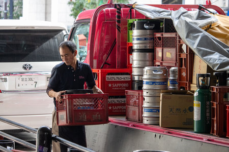 Tokyo, Japan, November 6, 2023: Delivery man unloading crates and kegs