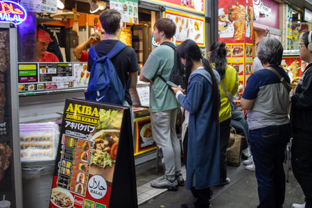 Tokyo, Japan, November 6, 2023: Customers queuing at a street food stallのeditorial素材