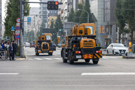 Tokyo, Japan, November 6, 2024: Urban Construction Vehicles and Pedestriansのeditorial素材