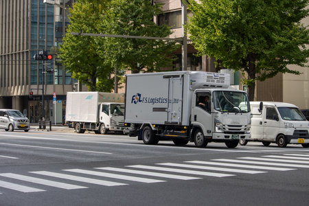 Tokyo, Japan, November 6, 2024: Urban Delivery Trucks at Intersectionのeditorial素材