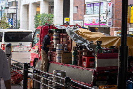 Tokyo, Japan, November 6, 2024: Delivery Worker Unloading Kegs from Truck