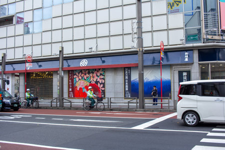 Tokyo, Japan, November 6, 2024: Urban Street Scene with Cyclists and Mural Artのeditorial素材