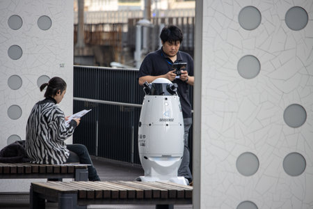 Tokyo, Japan, November 6, 2024: Autonomous Security Robot and People in Urban Settingのeditorial素材