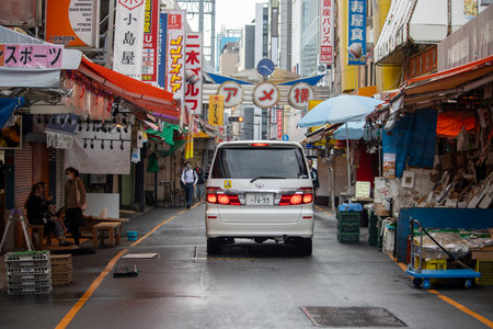 Tokyo, Japan, November 6, 2024: Urban Street Scene with Van and Colorful Shop Bannersのeditorial素材