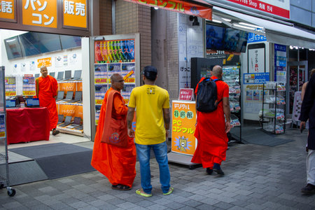 Tokyo, Japan, November 6, 2024: Buddhist Monks Browsing Electronics Storeのeditorial素材