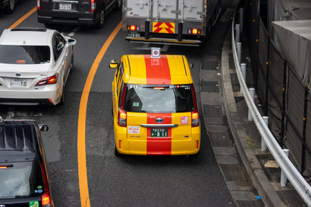 Tokyo, Japan, November 6, 2024: Traffic Scene with Yellow Taxi and Private Carsのeditorial素材