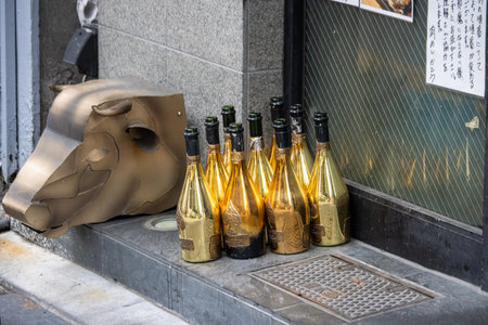 Tokyo, Japan, November 7, 2024: Empty Bottles and Bull Sculpture on Urban Sidewalkのeditorial素材
