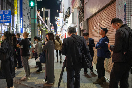 Tokyo, Japan, November 7, 2024: Night Scene of Busy Tokyo Street with Pedestrians and Illuminated Signsのeditorial素材
