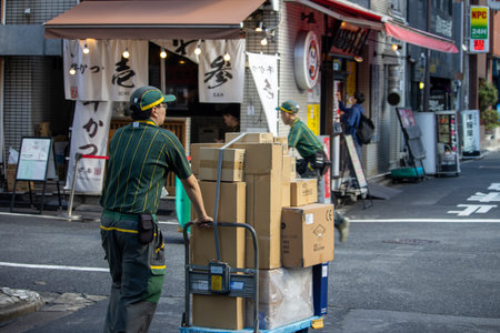 Tokyo, Japan, November 7, 2024: Delivery Workers Unloading Boxes in Urban Setting