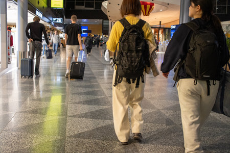 Helsinki, Finland, November 8, 2024: Airport Travelers with Backpacks Walking in Terminalのeditorial素材