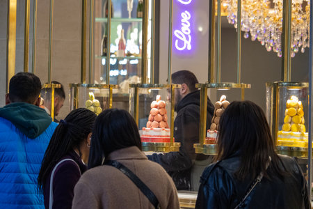 Paris, France, November 9, 2024: Macaron Shop Display with Customers
