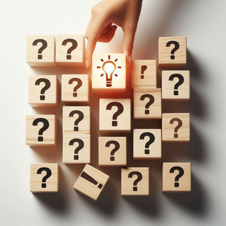 Top view of human hand and wooden cubes with question marks on white background