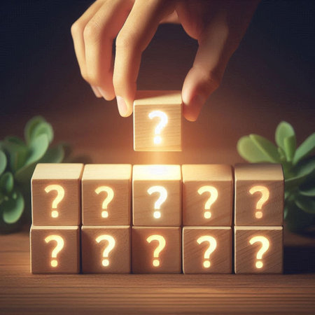 Conceptual image of human hand putting wooden cube with question mark on topの写真素材