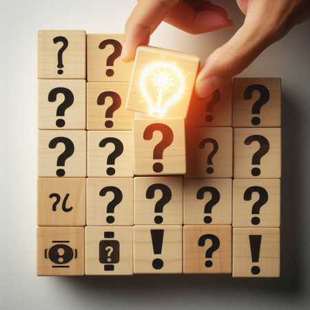 Human hand placing wooden cube with light bulb on top of question markの写真素材