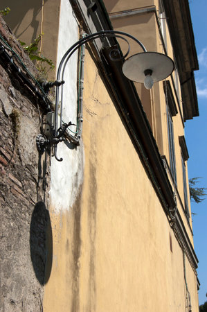 Street lamp on historic building in Lucca, Tuscany, Italyの写真素材
