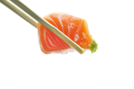 Chopsticks pinch fresh salmon sushi and wasabiの写真素材