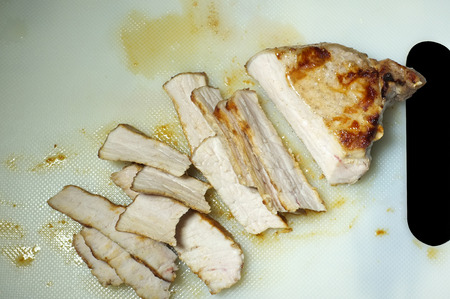 Slice of grilled pork on white plateの写真素材