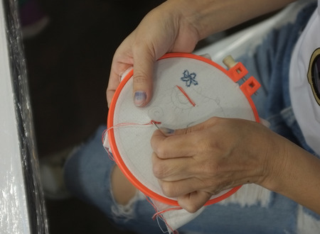 Concept workshop embroidery , Close up of embroidery .  Woman hands doing cross-stitch.の写真素材