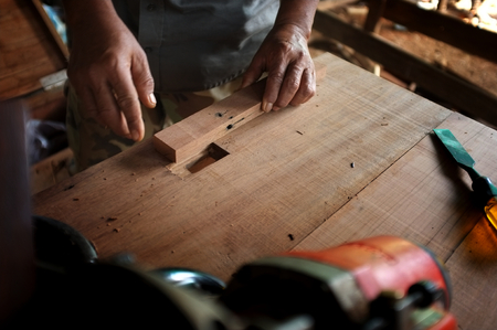 equipment on wooden desk with man working in workshop backgroundの写真素材