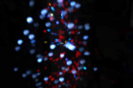 Blurred LED screen closeup. Glowing threads in a color spectrum on a black background. 