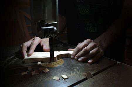 Carpenter builder working with electric jigsaw and wood. Woodworker cutting a piece of wood