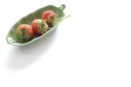Fresh Strawberry  in green dish. on white backgroundの写真素材