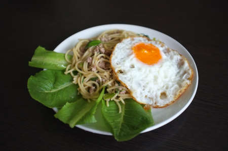 Spaghetti stir fried with Thai Basil spicy sauce with Fried egg  , fusion Thai styleの写真素材