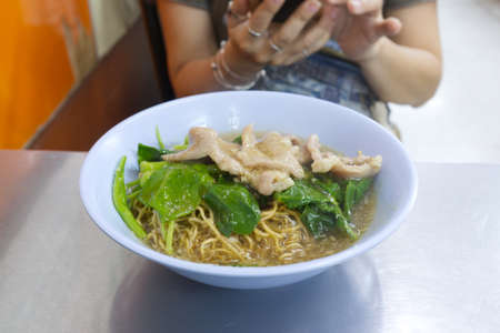 Crispy noodle in thick gravy with pork and chinese kaleの写真素材