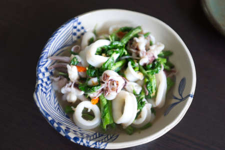 Fried basil leave with squid In a white bowl