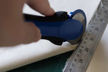 On the mat for patchwork sewing there are  knife for patchwork, a ruler,