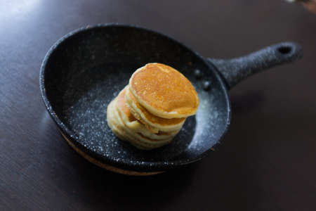 A pancakes in a frying pan on black backgroundの写真素材