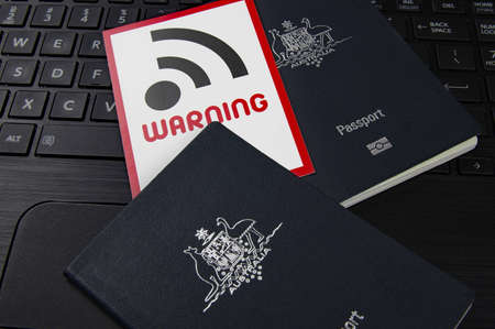 passports and wifi warning sign on a black computer keyboard