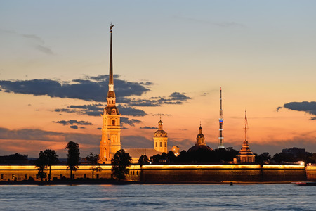Peter and Paul fortress view from the Palace embankment of the Neva river at sunset during the white nights in St. Petersburg. On the background of the red sky and the TV tower with illumination.のeditorial素材