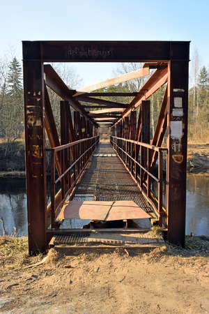 Metal pedestrian bridge across the river Oredezh in the village of Vyritsaの写真素材