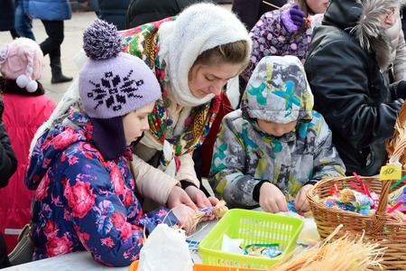 ST.PETERSBURG, RUSSIA - MARCH 13, 2016: Young girl - the master teaches children to make solomonow figurine carnival at the master class at the Moscow squareのeditorial素材