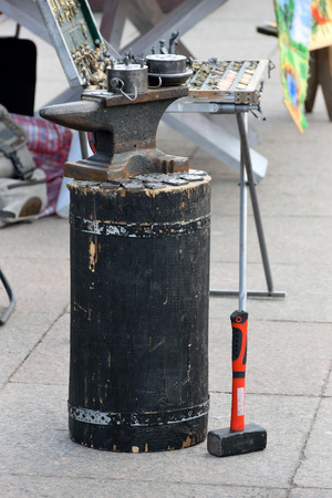 ST.PETERSBURG, RUSSIA - MARCH 13, 2016: Anvil, blacksmith hammer is ready and Souvenirs - coins and trinkets on the holiday of Maslenitsa at Moscow squareのeditorial素材