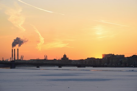 Golden sunset , the view of the Annunciation bridge and Smoking pipes from the Admiralty embankment in winter in St. Petersburgの写真素材
