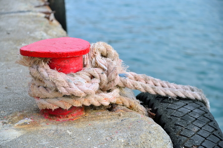 Red stand on the pier with a rope and tyre. Crimea.の写真素材