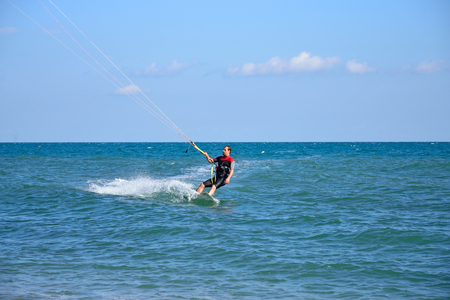 A man in a wetsuit floating on the Board while holding the kite. Crimeaの写真素材