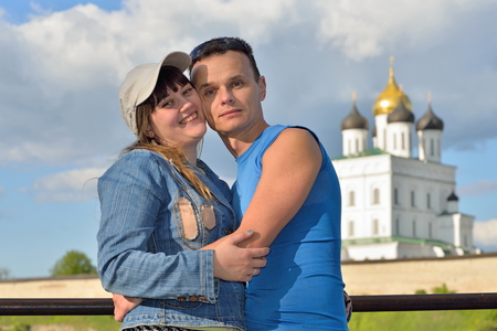 A young man embraces the girl on the background of the Trinity Cathedral in Pskovの写真素材