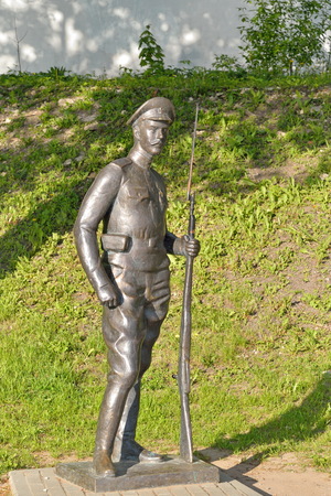 A statue of a soldier with a rifle on the embankment of the river greatの写真素材