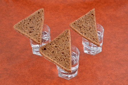 Pieces of black bread on the shots of vodka on the table.の写真素材
