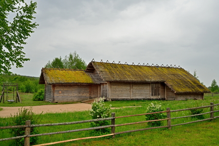 Old wooden log barn in the Museum of Pushkin Mikhailovskoe village summer cloudy dayの写真素材