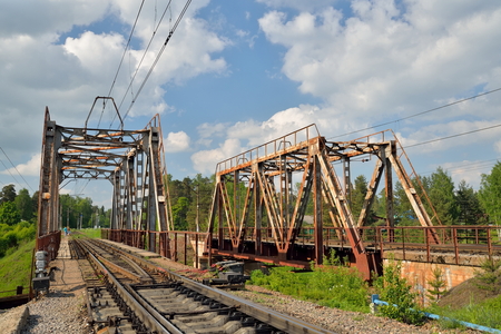 Railway bridge across the river and the rails with the arrow in Vyritsa in the summerの写真素材