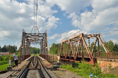 Railway bridge across the river and the rails with the arrow in Vyritsa in the summerの写真素材
