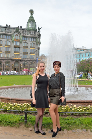 Girls pose in front of the fountain and book House of singer on Nevsky prospect in Saint-Petersburgの写真素材